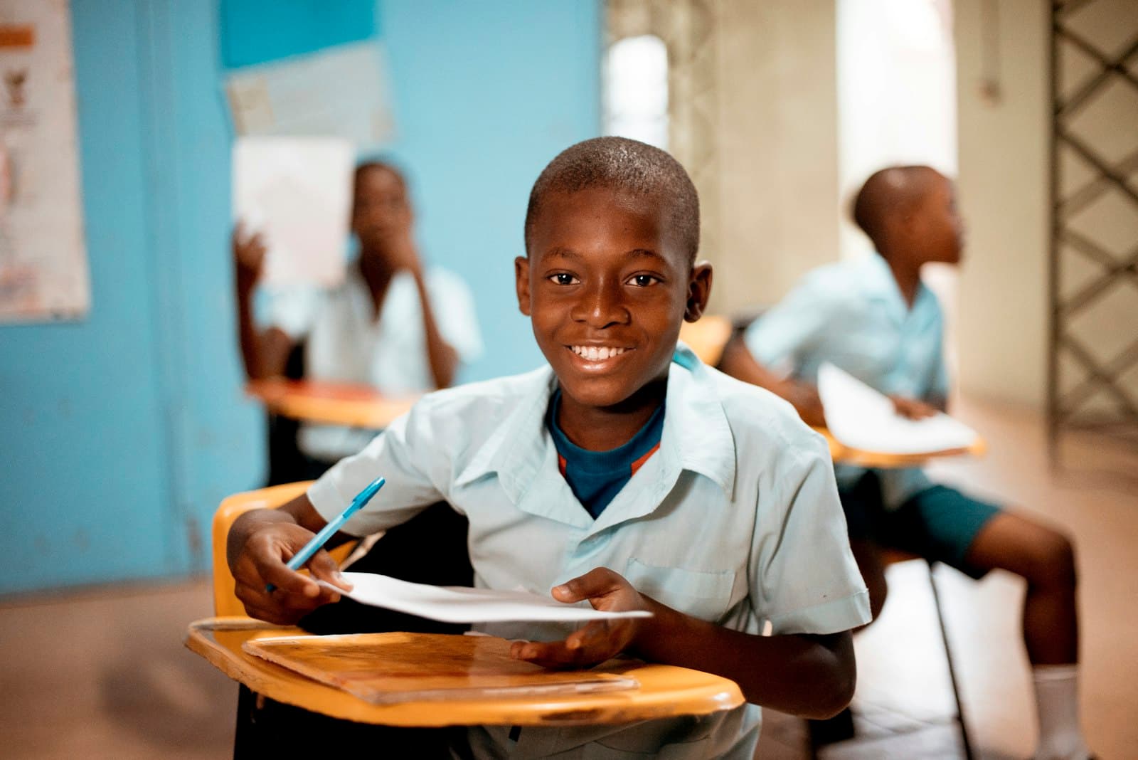 Smiling student holding their work